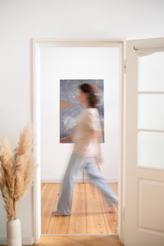 Portrait einer Designerin mit Fokus auf ihre Leinwand. Die Leinwand ist klar und sie geht an der Leinwand vorbei und ist verschwommen